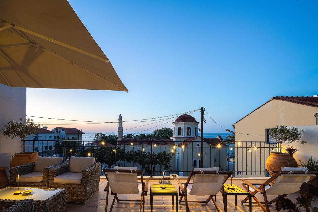 a patio with tables and chairs and a building at Villa Aposperitis in Panormos Rethymno