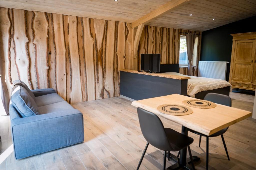 a room with a bed and a table and a couch at Oh la vache in Stoumont