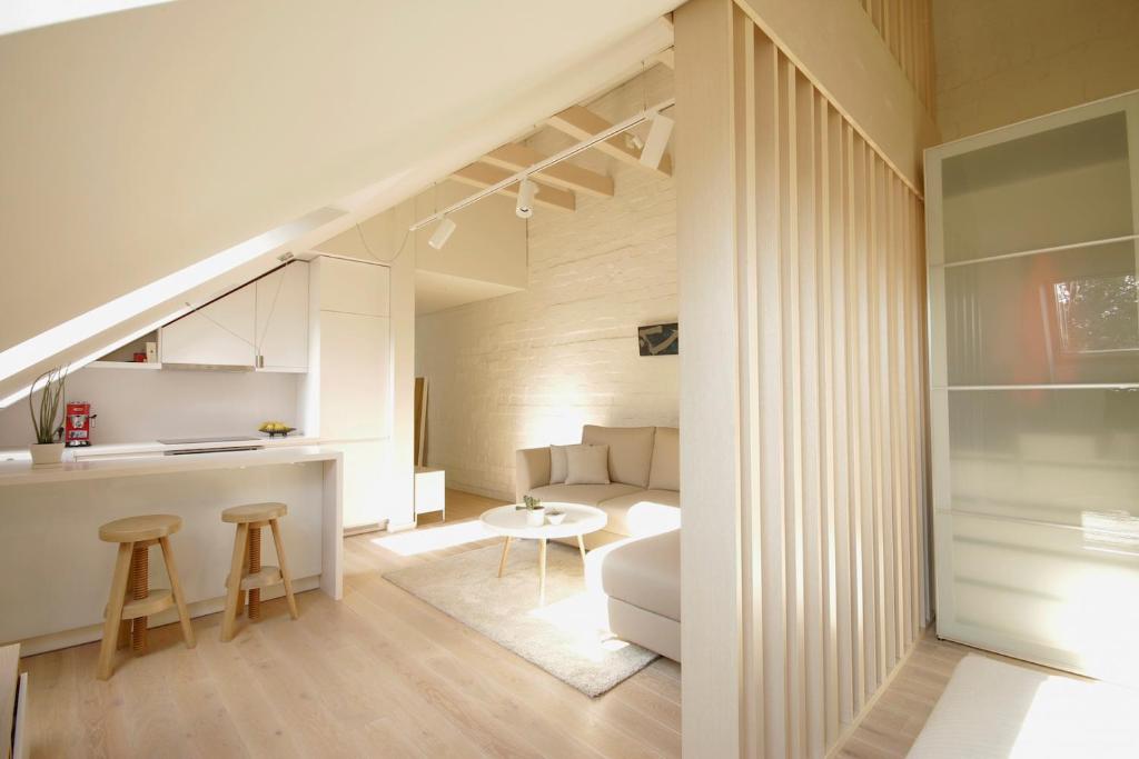 a kitchen and living room with a couch and a table at Old Town Apartment with FREE Parking in Marijampolė