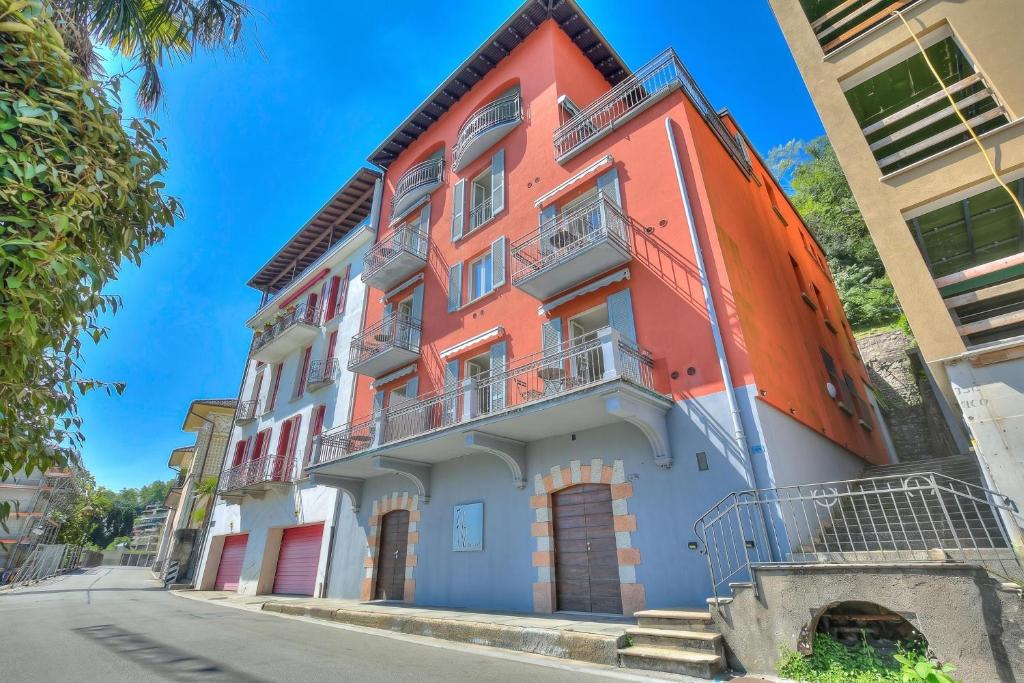 an orange and white building on the side of a street at 76 The Lake House - Lugano in Melide