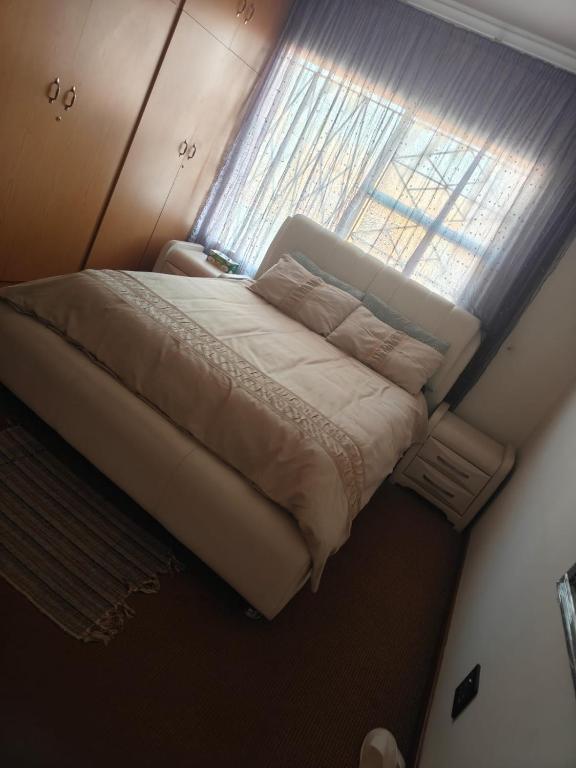 a bed in a small room with a window at The Corner Lounge - Lenasia in Lenasia