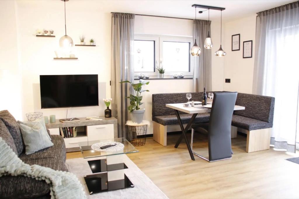 a living room with a couch and a table at Kapellenblick Auszeit mit Ausblick in Heroldstatt