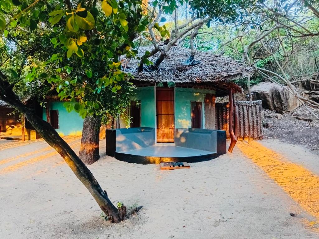a small house with a tree in front of it at Nilaveli Eco Lodge in Nilaveli