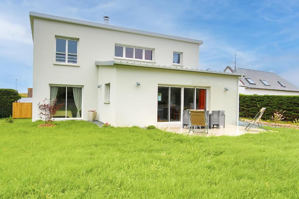 a white house with a lawn in front of it at La Houle in Créances