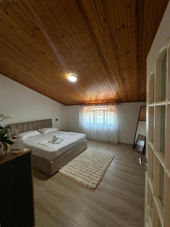 a bedroom with a bed and a wooden ceiling at Drini river view in Shkodër