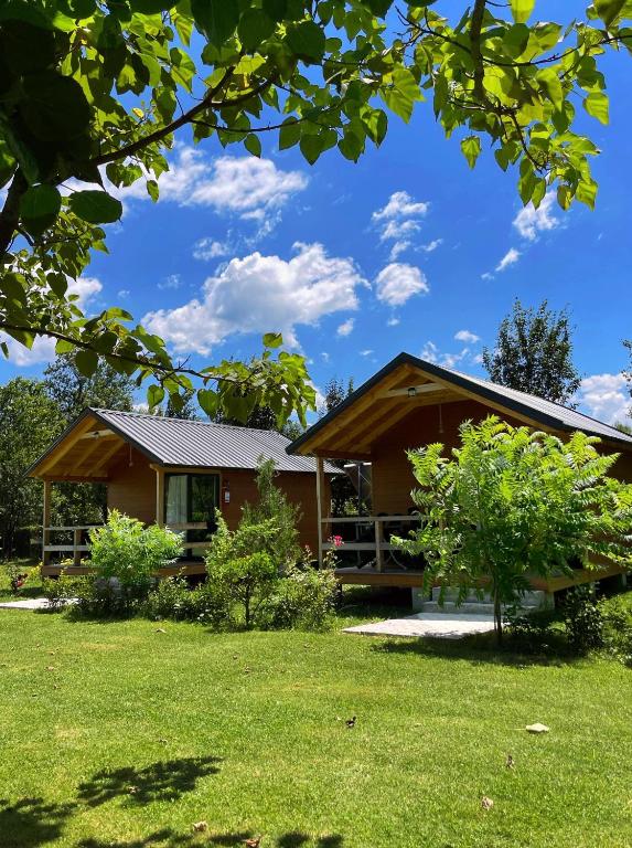 a house with a green lawn in front of it at Hotel Restorant Natyra Diber Camping in Podgorcë