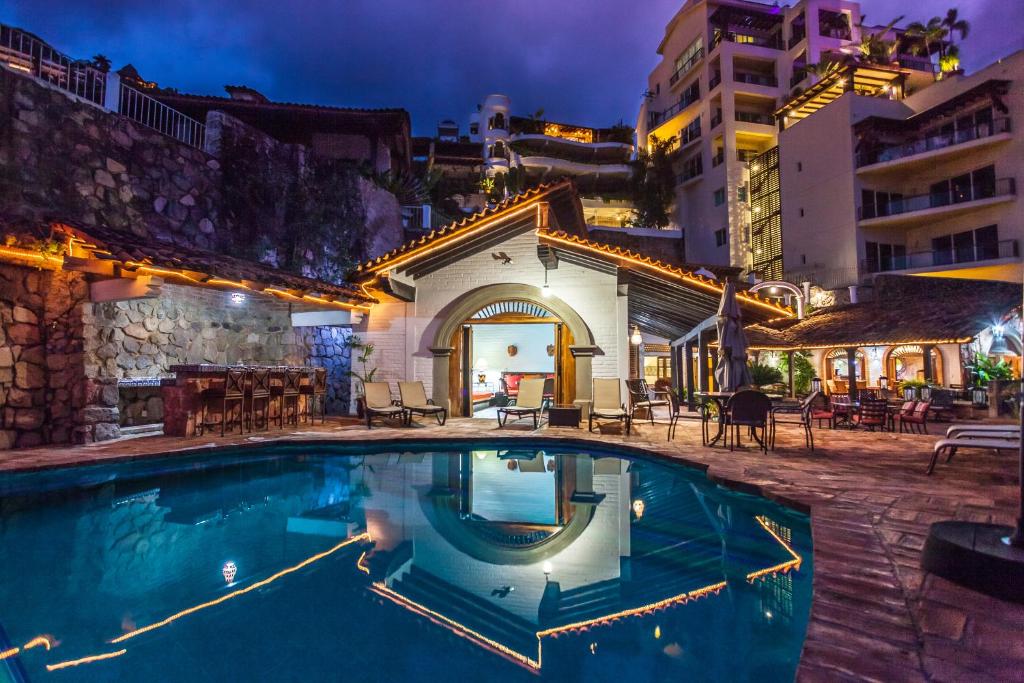 a swimming pool in front of a building at night at Villa Celeste in Puerto Vallarta