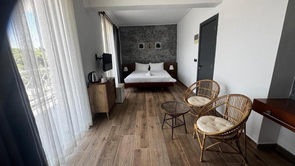 ein Schlafzimmer mit einem Bett, einem Tisch und Stühlen in der Unterkunft Li Mango in Tigaki