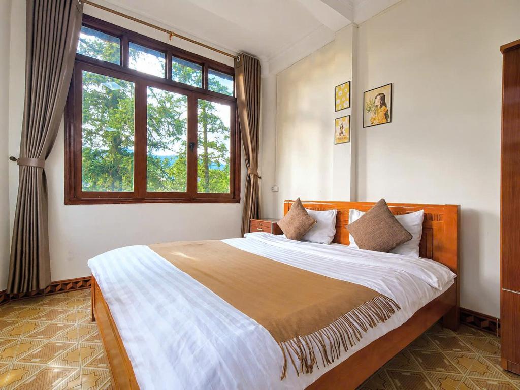 a bedroom with a large bed and a window at Nấm Homestay in Sapa