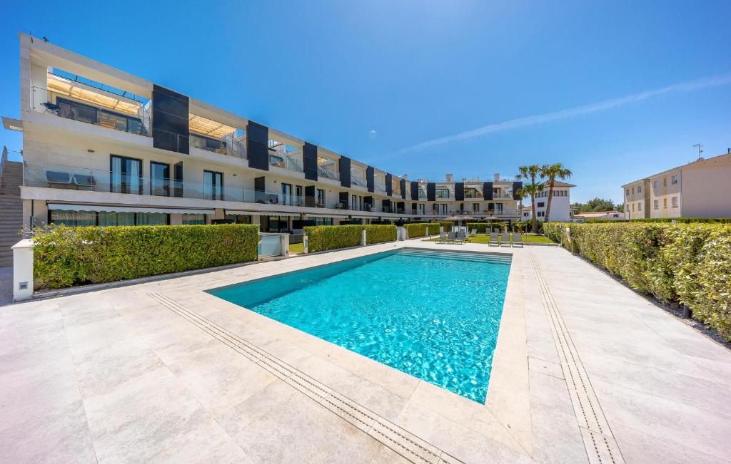 a swimming pool in front of a building at La Perla Puerto Pollença 9 in Pollença