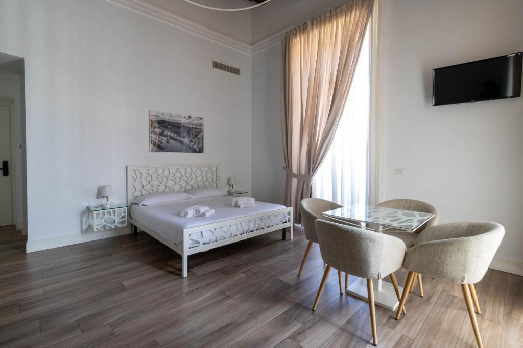 a bedroom with a bed and a table and chairs at Villa Cua in Ercolano