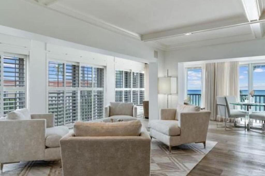 a living room with white furniture and a view of the ocean at Three Bedroom Gulffront Condo with Sunset Views in Naples