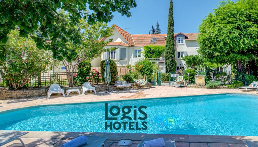 a swimming pool in front of a house at Logis Hotel Le Blason de Provence in Monteux