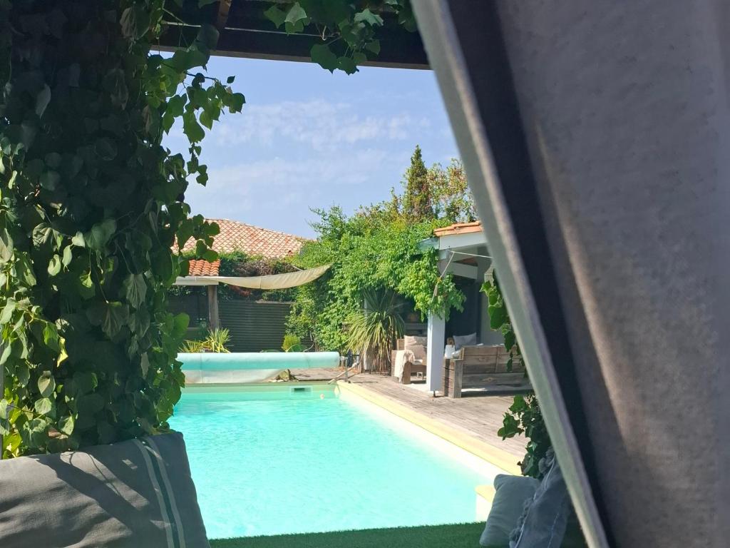 a swimming pool with a view of a house at La Villa du Teich in Le Teich