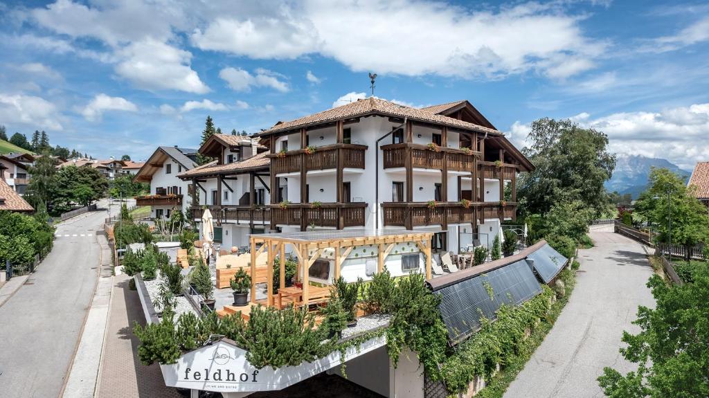 a house with a wrap around porch on a street at Aparthotel Feldhof Nature in Bolzano