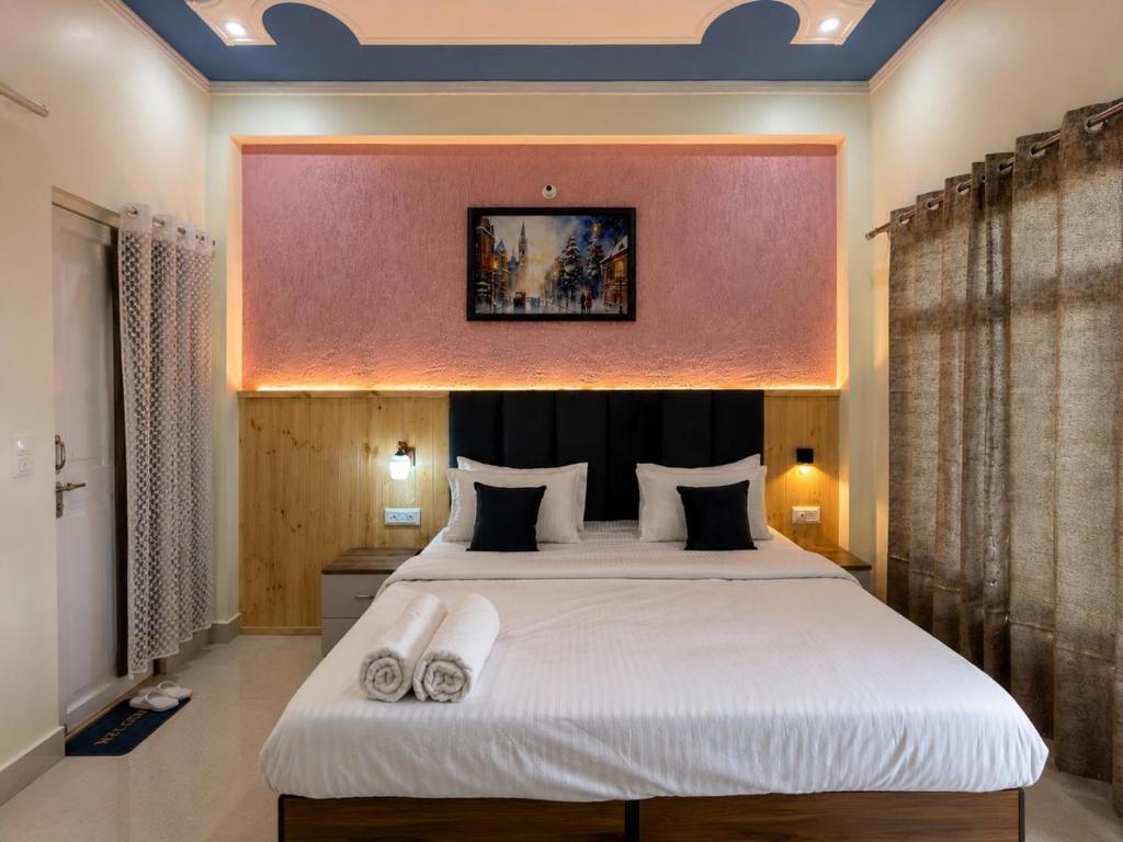 a bedroom with a large bed with two towels on it at Anamika Forest View 1RK Near Kempty Falls Mussoorie in Mussoorie