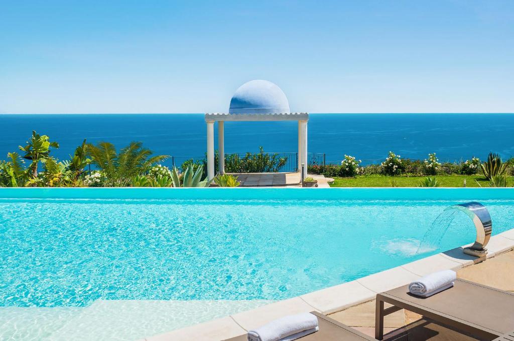 a swimming pool with a gazebo and the ocean at Buena Vista in Letojanni