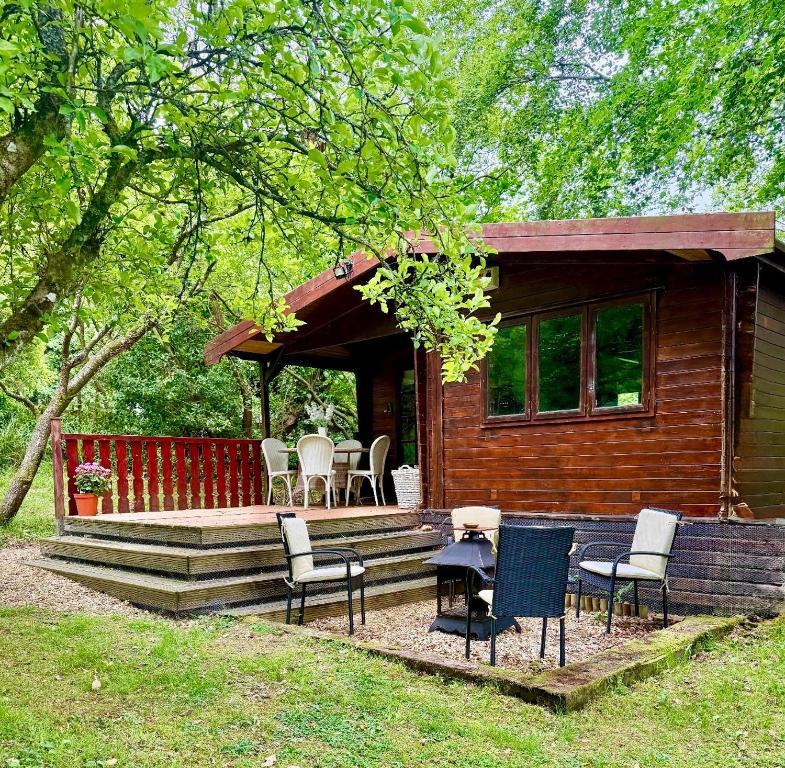 a log cabin with chairs and a table on the porch at The Cabin at The Oaks in Fordingbridge