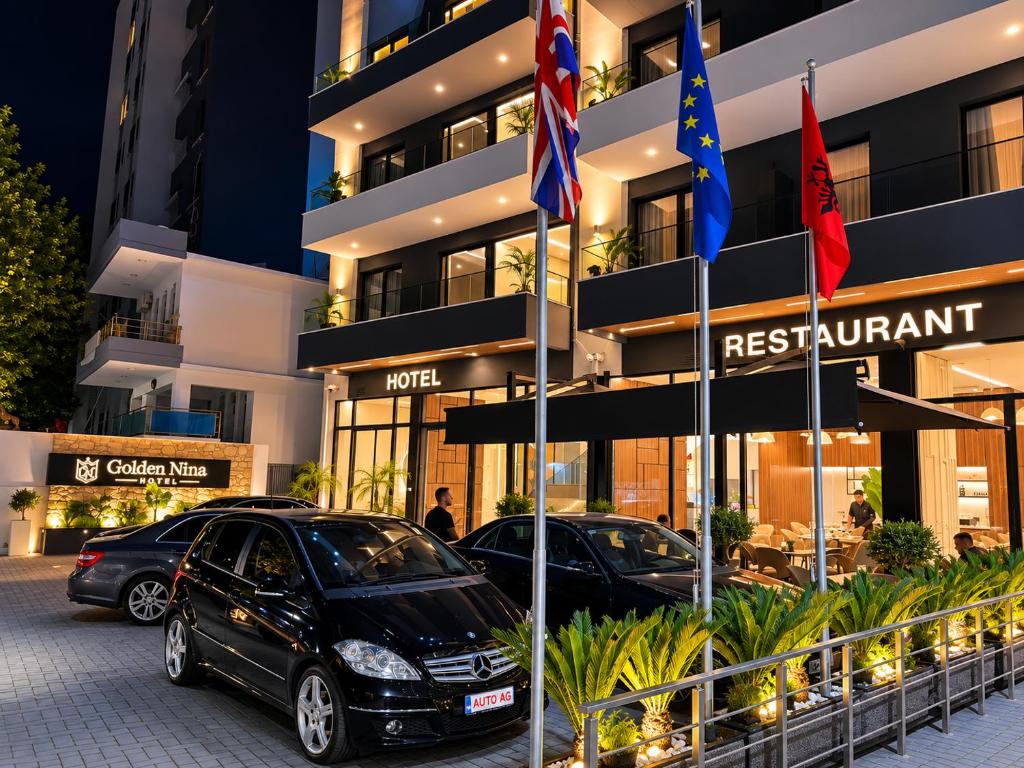 two cars parked in front of a hotel at Golden Nina Hotel in Vlorë