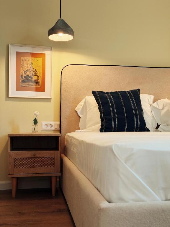 a bedroom with a bed with a black and white pillow at Hotel "Villa Niche" By Bratheim in Tirana