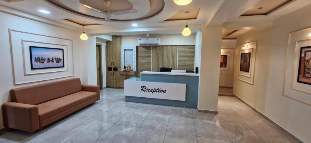 a waiting room with a couch in a lobby at Hotel Krishna Palace in Pālanpur