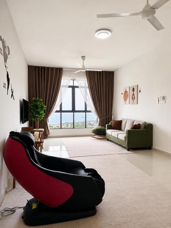a living room with a red and black couch at Seabreeze Hideout at Pantai Klebang Netflix I Wifi I Massage Chair I 7 pax in Malacca