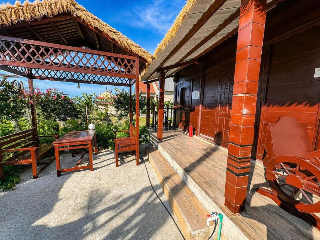a porch of a house with a table and a chair at Củi Homestay Huế in Hue
