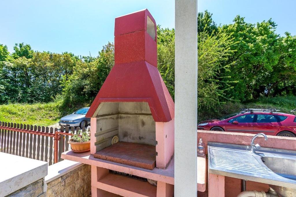 a brick oven on a balcony with a car parked at Apartment Dragica in Valbandon