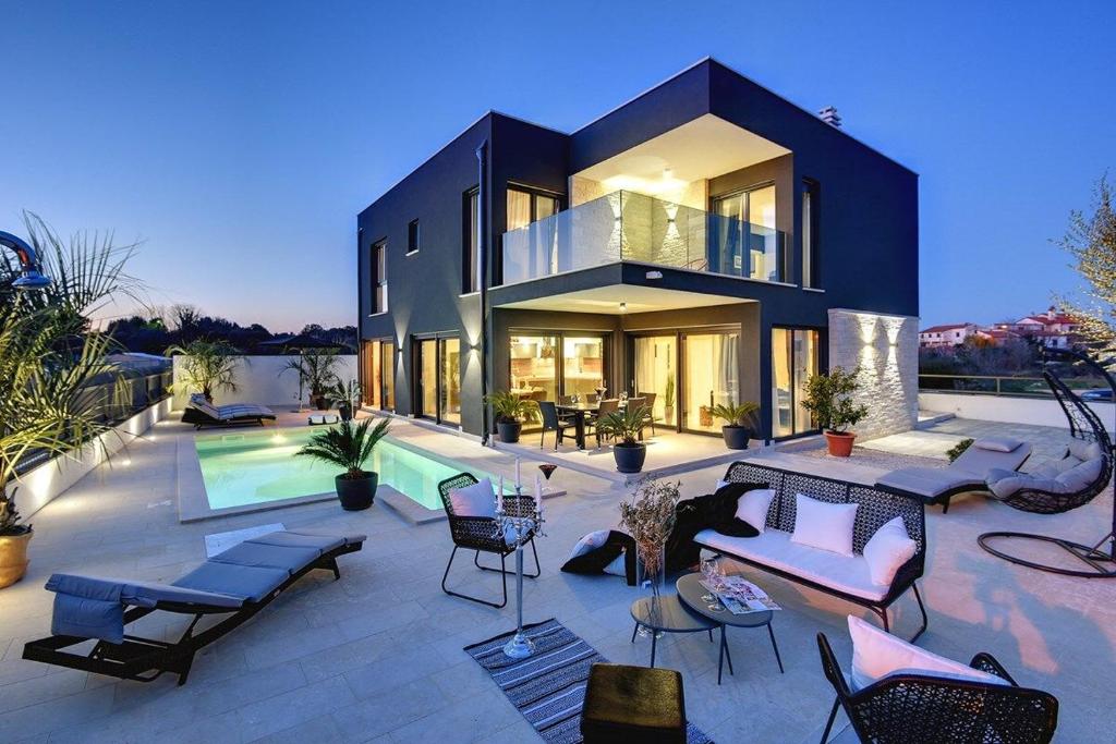 a large house with a patio and a swimming pool at Villa Orion - Private Heated Pool, Sauna & Jacuzzi in Rovinj