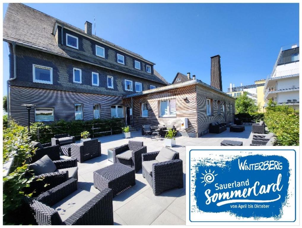 a building with chairs and a sign in front of it at Die zwei Löwen Ferienwohnungen in Winterberg
