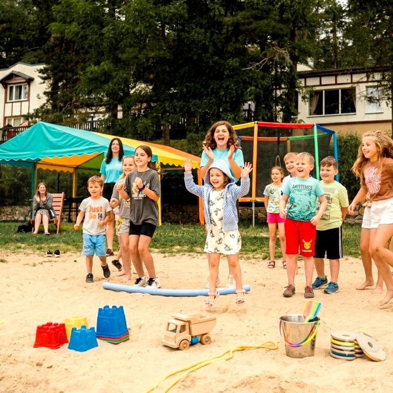 a group of children playing in the sand at Zawiaty rodzinne wakacje z animacjami dla dzieci in Czarna Dąbrówka