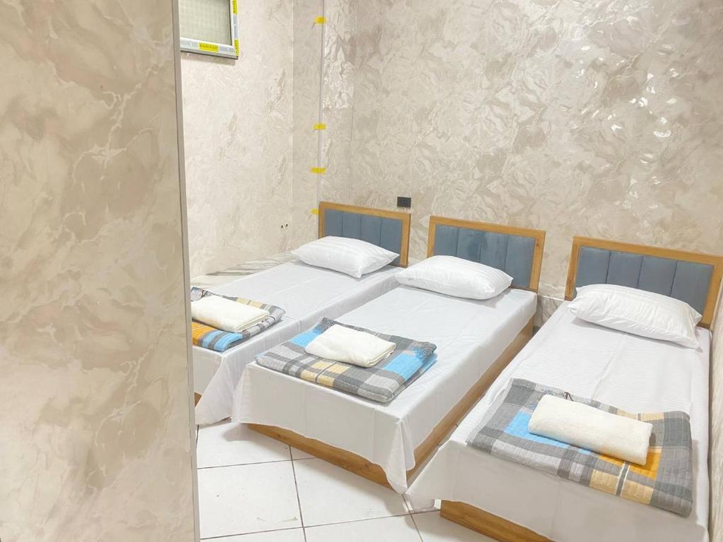 two beds in a room next to each other at Shinam hostel 777 in Chilanzar