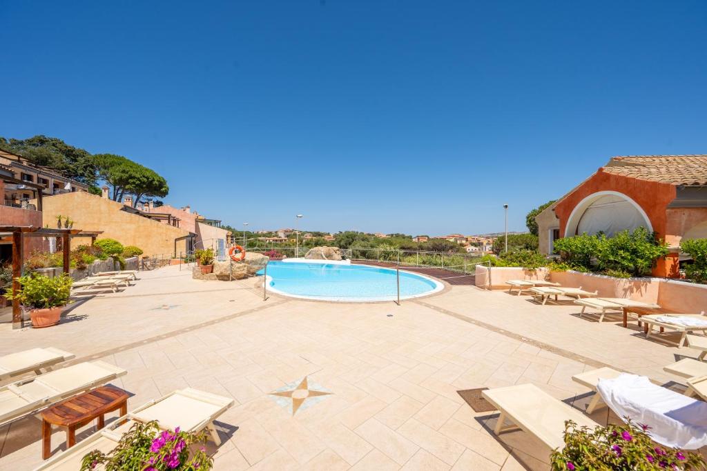a patio with a swimming pool and lounge chairs at A 104 Puntavilla in La Maddalena