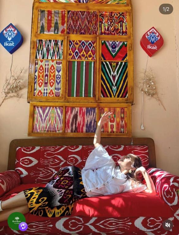 a woman laying on a bed in a room at Gulzar Village Guesthouse in Dushanbe