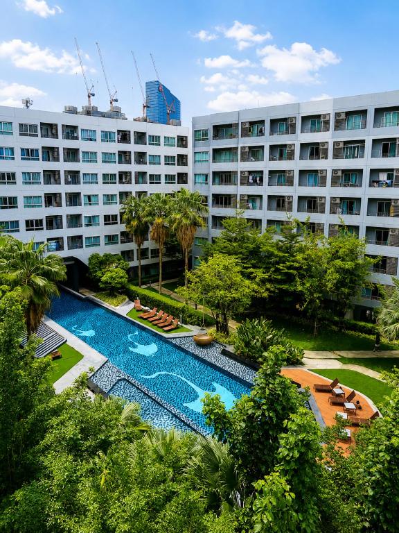 a resort with a swimming pool and a large building at Easy Access Studio Near BTS in Amphoe Phra Khanong