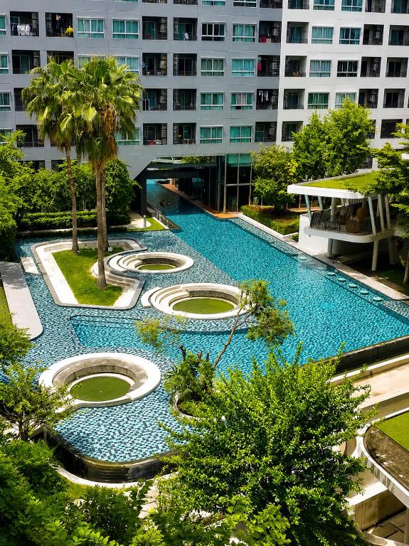 a large swimming pool in a city with a building at Pool Studio Near BTS Quiet Stay in Amphoe Phra Khanong