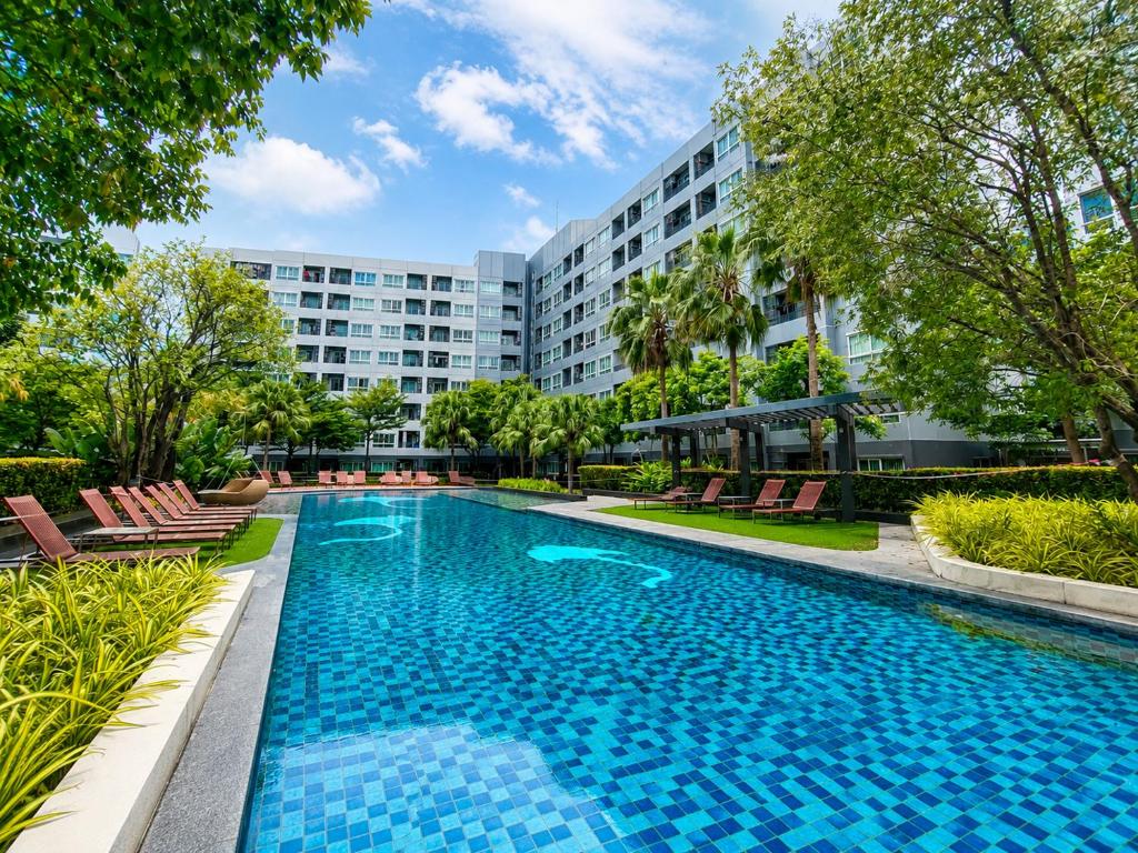 a swimming pool in front of a building at Spacious Studio Near BTS Kitchen & Washer in Amphoe Phra Khanong
