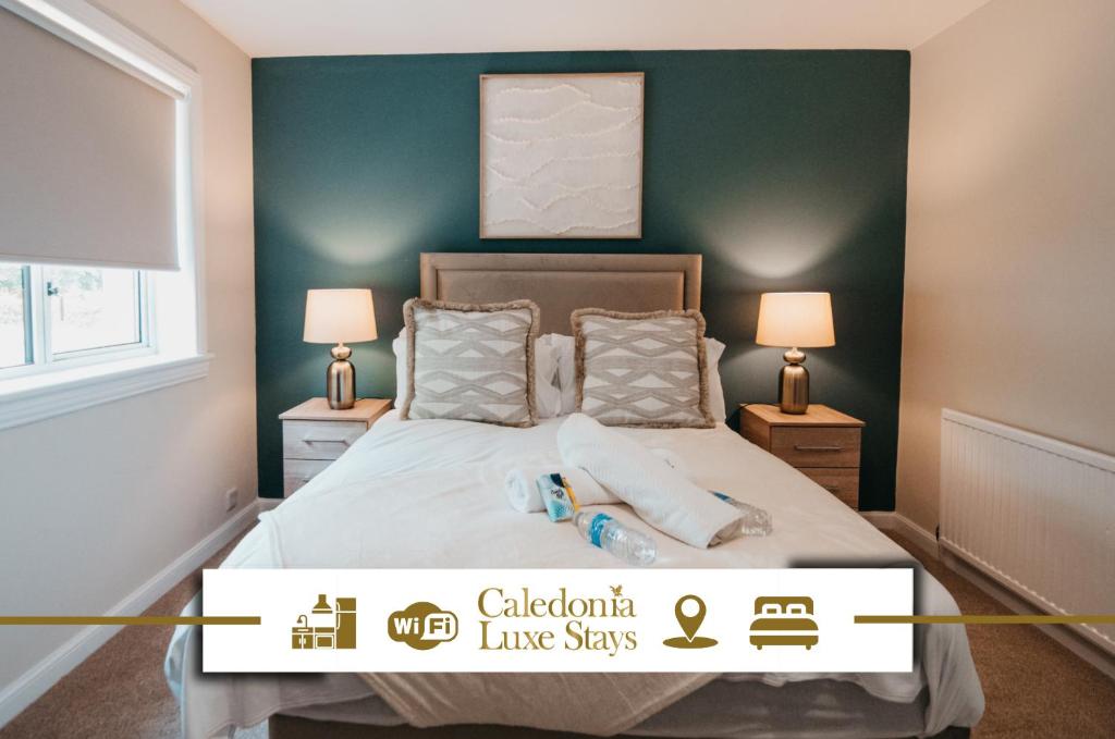 a bedroom with a bed with green walls and two lamps at The Livingston Nest in Livingston