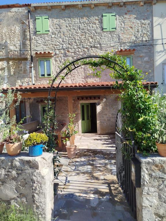 an entrance to a stone building with a gate at Loparina House in Nerezine
