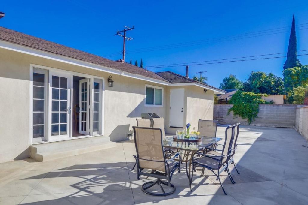 a patio with a table and chairs in front of a house at Beautiful Remodel 3 Bedroom 2 bathroom Home with Pool & Jacuzzi in Fullerton