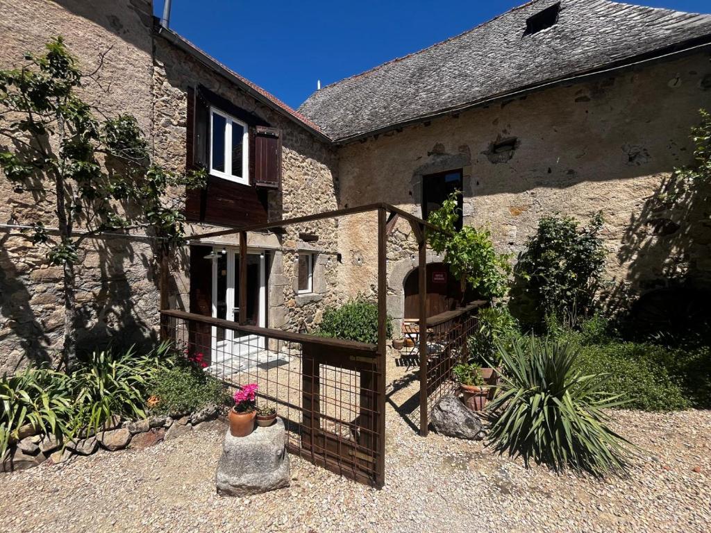 a stone house with a gate in front of it at Gîte authentique avec piscine en Aveyron in Morlhon-le-Haut