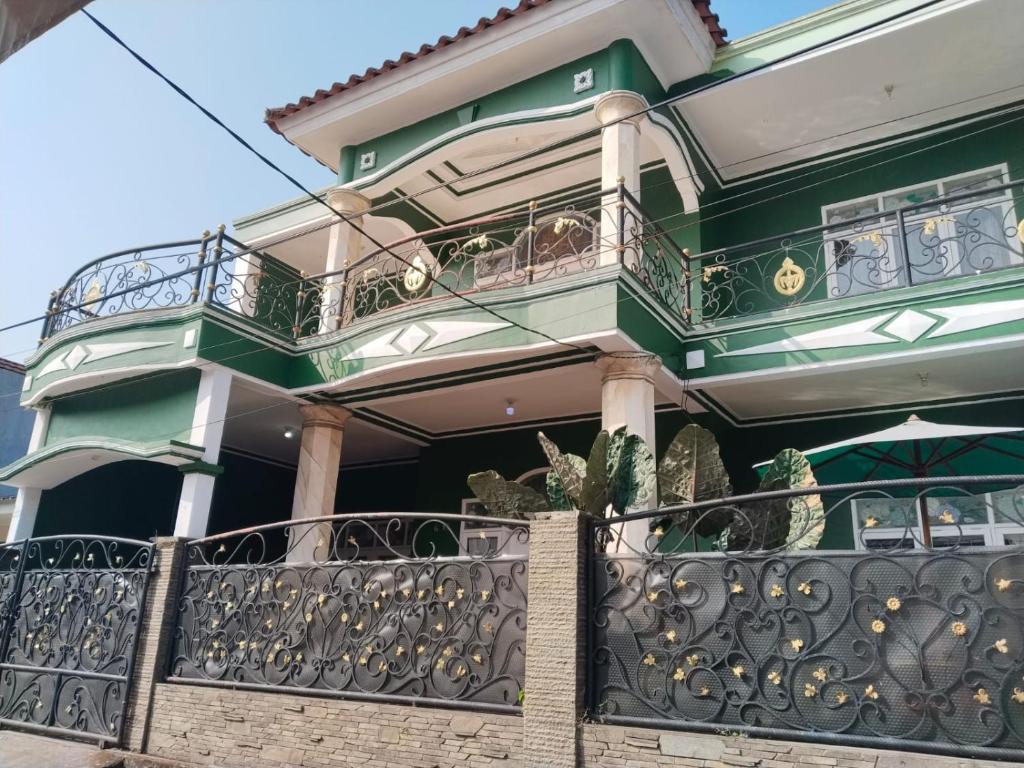a green and white house with a balcony at Priv garut in Garut