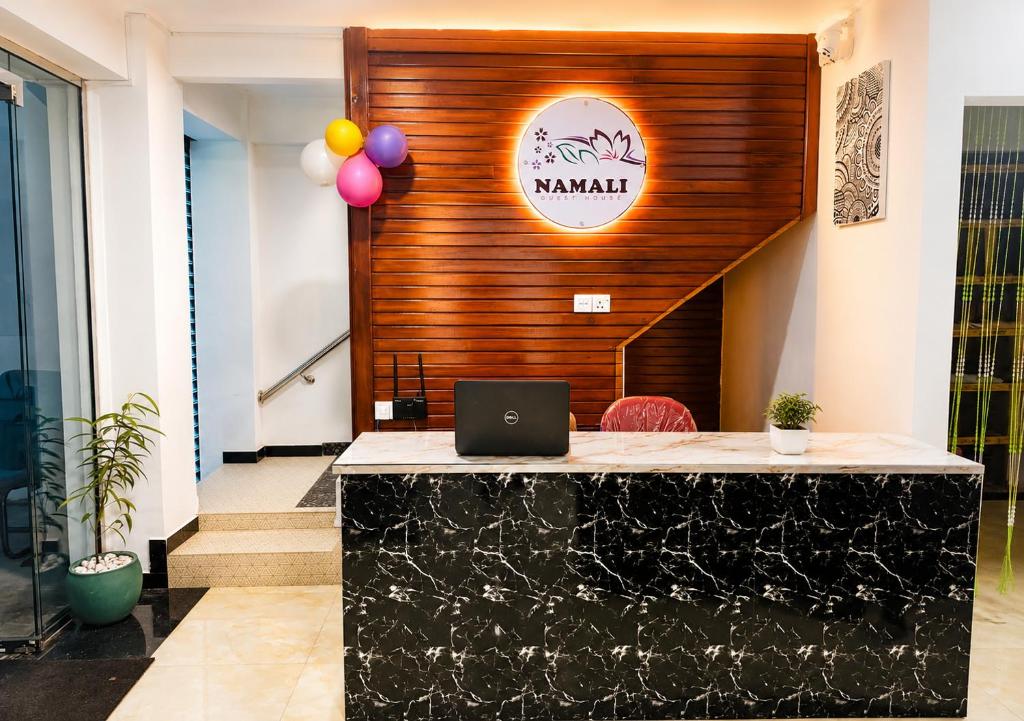 a lobby with a desk with a laptop on it at Namali Guest House in Badulla