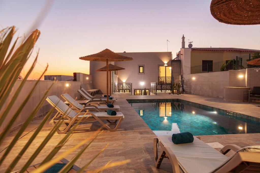 a swimming pool with lounge chairs and a house at Casa Gabriel in Estômbar