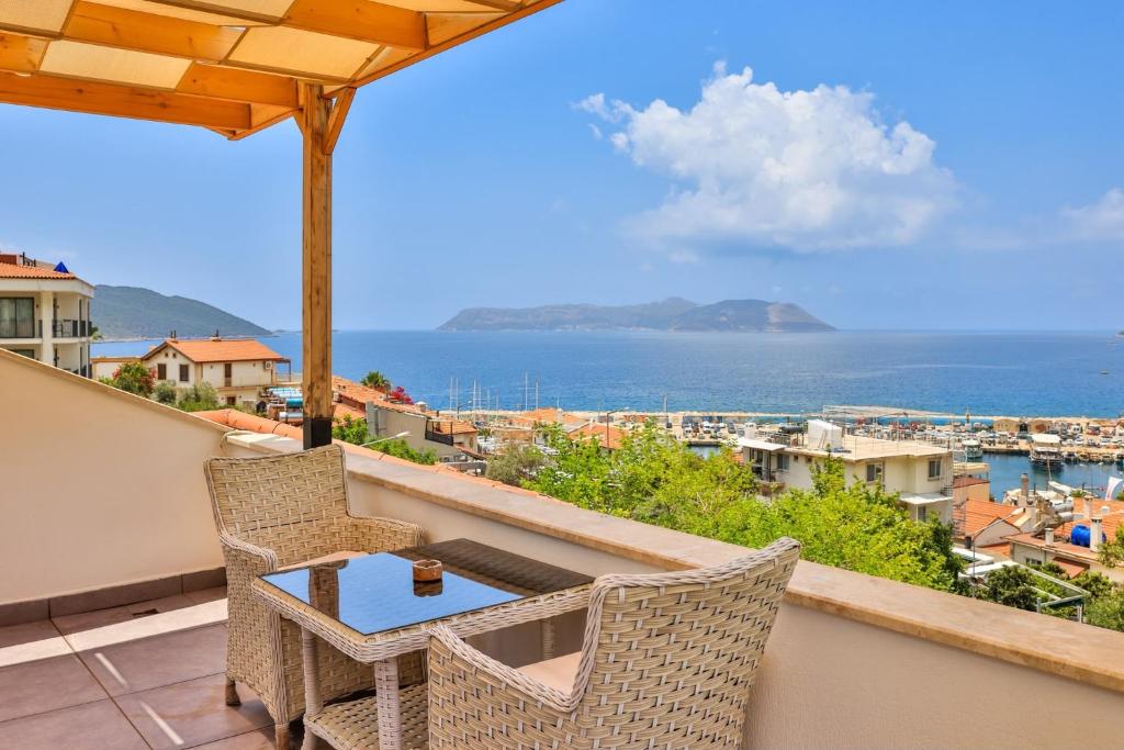 a balcony with a table and chairs and the ocean at The Townhouse Apartment in Kaş