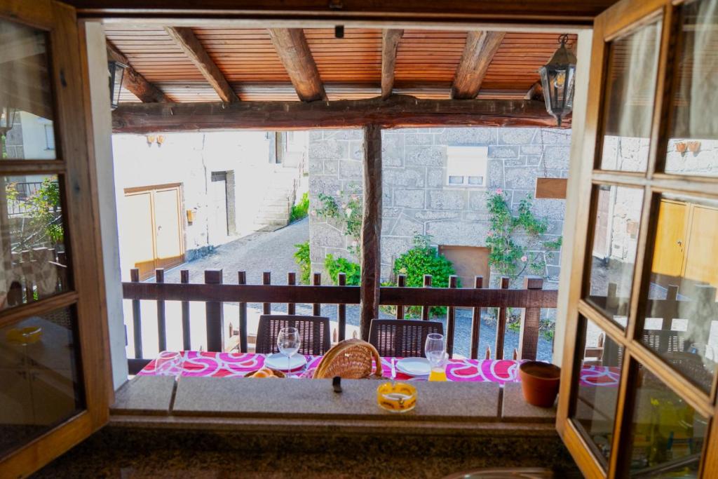 a table on a balcony with a view of a building at Casa das Marias by Gerês Casas in Geres