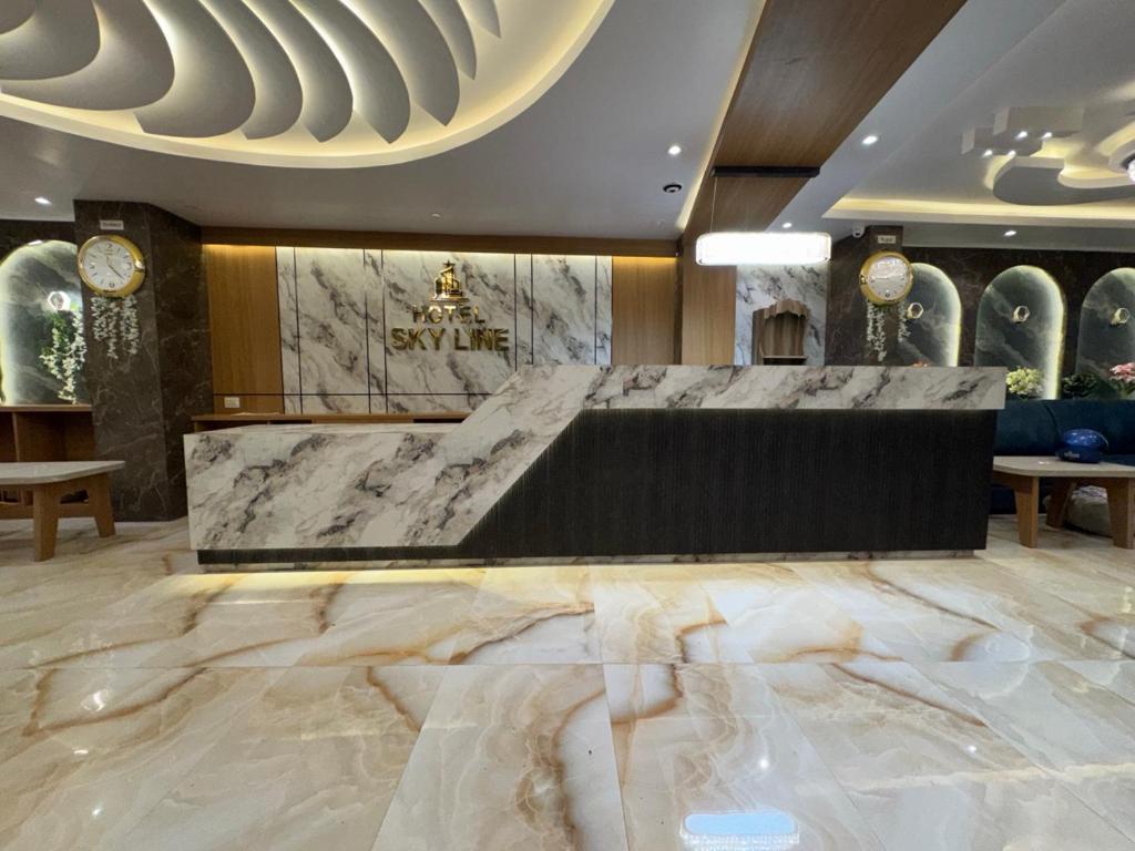 a lobby with a large marble floor and a counter at Hotel Skyline in Janakpur