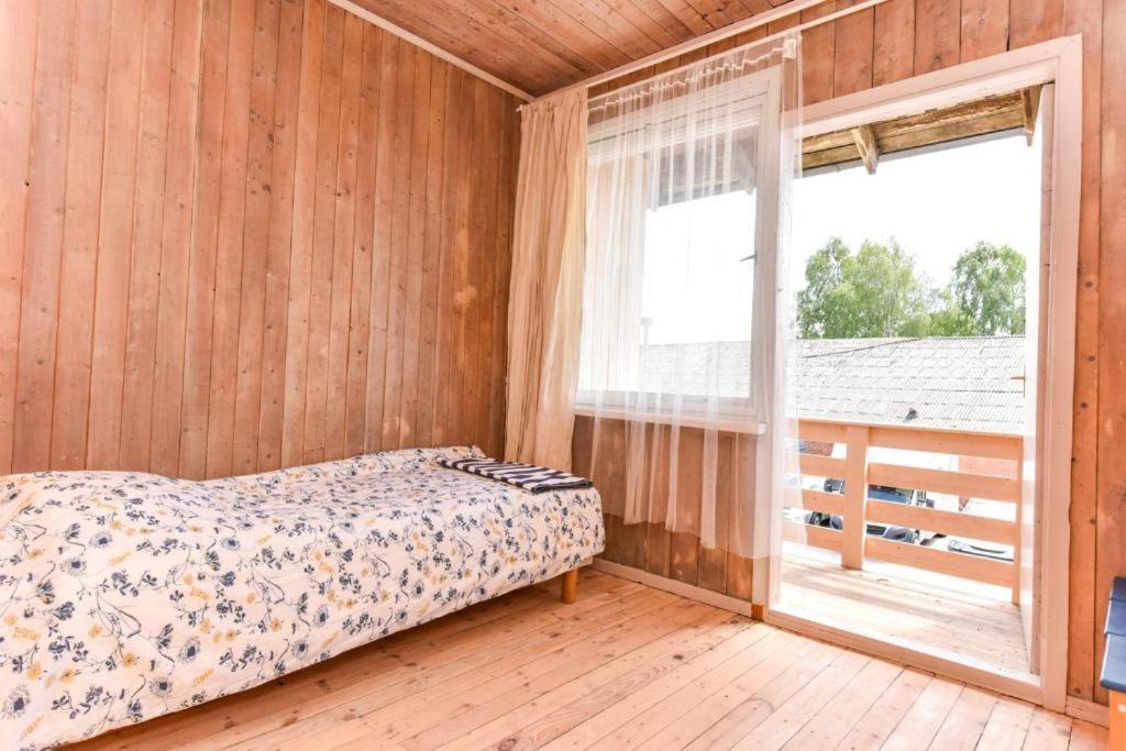 a bedroom with a bed and a large window at Private double room with balcony in Neringa