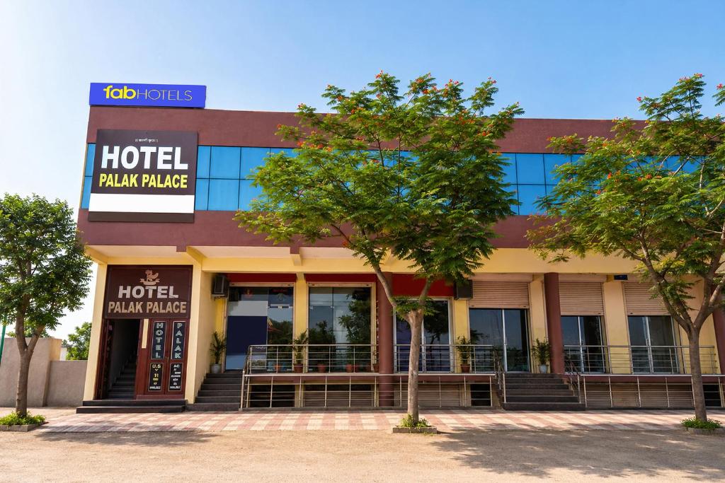 a hotel plaza palace building with trees in front of it at FabHotel Palak Palace in Jaipur