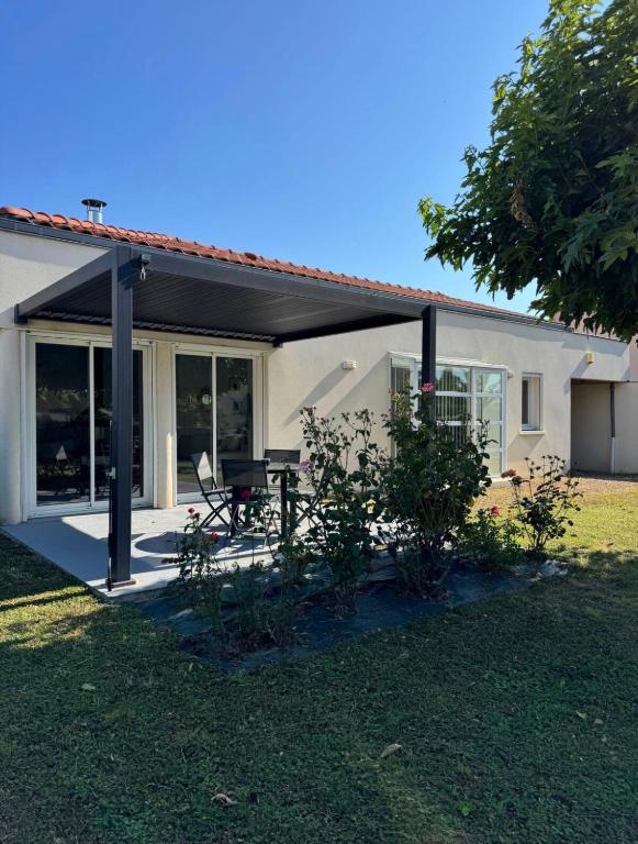a house with a porch with a picnic table in the yard at Maison d'architecte in Cébazat